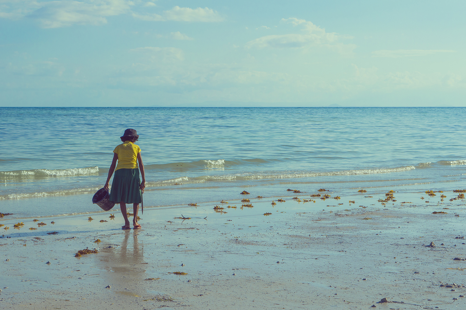 Giulia Brunetti - photography of an old lady looking for mussels on a shore